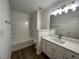 Bright bathroom featuring a bathtub with tile surround and a vanity with modern fixtures at 358 Azalea Cir, Cumming, GA 30040