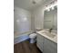 Bright bathroom featuring a bathtub with tile surround and a vanity with modern fixtures at 358 Azalea Cir, Cumming, GA 30040