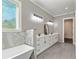Bright bathroom featuring double vanity sinks, a soaking tub, and a separate shower at 5241 Moon Rd, Powder Springs, GA 30127