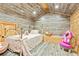 Bedroom featuring a white metal bed, wood paneling and sloped ceilings at 5241 Moon Rd, Powder Springs, GA 30127