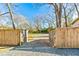 Gravel driveway and wooden gate create a welcoming entrance to the sprawling property at 5241 Moon Rd, Powder Springs, GA 30127