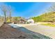 Exterior view of white barn-style home with a pergola and gravel parking area at 5241 Moon Rd, Powder Springs, GA 30127