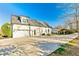 White home exterior with a three-car garage, long driveway, and outdoor pergola at 5241 Moon Rd, Powder Springs, GA 30127