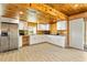 Bright kitchen features white cabinets, stainless steel refrigerator and wood-paneled walls at 5241 Moon Rd, Powder Springs, GA 30127
