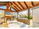 Covered outdoor kitchen with stone countertops, a fireplace, and mounted TV, blending comfort and functionality at 5241 Moon Rd, Powder Springs, GA 30127