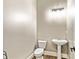 Modern powder room with pedestal sink, decorative lighting, and wood-look floors at 5241 Moon Rd, Powder Springs, GA 30127