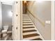 Staircase features wood treads, white risers, and leads to a door with a powder room behind it at 5241 Moon Rd, Powder Springs, GA 30127