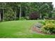 Well-manicured backyard features mature trees, vibrant landscaping, and plenty of space for outdoor activities at 6040 Boulder Bluff Dr, Cumming, GA 30040