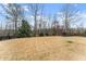 Large grassy backyard with mature trees and wooden fence, offering privacy and space at 6040 Boulder Bluff Dr, Cumming, GA 30040