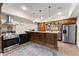 Open basement bar area with wooden cabinets, stainless steel appliances, and brick accent walls at 6040 Boulder Bluff Dr, Cumming, GA 30040