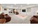 Expansive basement with leather sofas and a full wall of white built-in shelving at 6040 Boulder Bluff Dr, Cumming, GA 30040