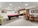 Spacious basement area with pool table and dining set, featuring brick accent wall at 6040 Boulder Bluff Dr, Cumming, GA 30040