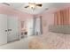 Pink bedroom with ceiling fan, neutral carpet, and closet at 6040 Boulder Bluff Dr, Cumming, GA 30040