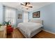 Calming bedroom with light blue walls, hardwood floors, neutral furniture, and large windows at 6040 Boulder Bluff Dr, Cumming, GA 30040