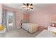 Pink bedroom with ceiling fan, neutral carpet, and large window with sheer curtains at 6040 Boulder Bluff Dr, Cumming, GA 30040