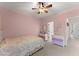 Pink bedroom with ceiling fan, neutral carpet, and large window at 6040 Boulder Bluff Dr, Cumming, GA 30040