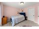 Cozy bedroom featuring pink walls, carpeted floors, and comfortable blue upholstered bed at 6040 Boulder Bluff Dr, Cumming, GA 30040