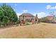 Spacious backyard with a playset, patio, and mature trees surrounding a beautiful brick home at 6040 Boulder Bluff Dr, Cumming, GA 30040