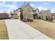 Spacious home featuring a long driveway and mature landscaping, showcasing the beautiful brick architecture at 6040 Boulder Bluff Dr, Cumming, GA 30040