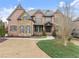 Beautiful two-story brick home featuring manicured landscaping, stone accents, and an elegant entrance at 6040 Boulder Bluff Dr, Cumming, GA 30040