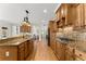 Kitchen island with wooden cabinets, granite countertops, and stainless steel appliances at 6040 Boulder Bluff Dr, Cumming, GA 30040