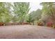 Spacious gravel backyard featuring mature trees and a wooden fence, providing privacy and a natural setting at 746 United Se Ave, Atlanta, GA 30312