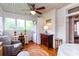 Cozy sunroom featuring hardwood floors, many windows, ceiling fan, and a dedicated laundry area at 746 United Se Ave, Atlanta, GA 30312