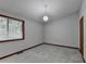 Empty bedroom with carpeted floors, baseboard trim, a window, and a light at 1922 Marshes Glenn Dr, Norcross, GA 30071