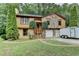 Charming home featuring a stone accent exterior, two-car garage and lush green lawn with mature landscaping at 1922 Marshes Glenn Dr, Norcross, GA 30071