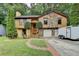 Charming home featuring a stone accent exterior, two-car garage and lush green lawn with mature landscaping at 1922 Marshes Glenn Dr, Norcross, GA 30071