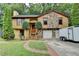 Charming home featuring a stone accent exterior, two-car garage and lush green lawn with mature landscaping at 1922 Marshes Glenn Dr, Norcross, GA 30071