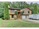 Charming home featuring a stone accent exterior, two-car garage and lush green lawn with mature landscaping at 1922 Marshes Glenn Dr, Norcross, GA 30071