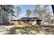 The home's backyard features mature trees, a flat lawn, and a brick exterior of the home at 3359 Mansfield Ln, Snellville, GA 30039