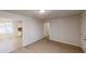 Open-concept living room with adjacent kitchen, featuring carpeted floors and ample natural light at 3359 Mansfield Ln, Snellville, GA 30039