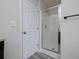 Bathroom featuring a glass shower door, light gray wood floors, and a white door to the left at 6334 Milo Dr, Austell, GA 30168