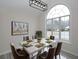 Elegant dining area showcasing a modern table setting, a statement art piece, and a large arched window at 6334 Milo Dr, Austell, GA 30168