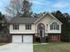 Charming home with a well-maintained lawn, a two-car garage, and an inviting entrance with decorative windows at 6334 Milo Dr, Austell, GA 30168