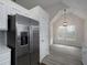 Kitchen area with stainless refrigerator, gray backsplash, and adjacent dining space under vaulted ceiling at 6334 Milo Dr, Austell, GA 30168