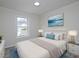 Digitally staged main bedroom featuring a comfortable bed, a window, and light gray wood floors at 6334 Milo Dr, Austell, GA 30168