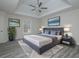 Well-furnished main bedroom featuring a tray ceiling, light gray wood floors, and artwork displayed at 6334 Milo Dr, Austell, GA 30168