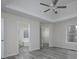 Main bedroom with a tray ceiling, light gray wood floors, and entrances to the bathroom and closet at 6334 Milo Dr, Austell, GA 30168