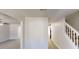 Bright hallway featuring hardwood floors and staircase with white railings at 6643 Hill Creek Cv, Lithonia, GA 30058