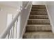 Carpeted staircase with white railing, providing access to the upper level at 6643 Hill Creek Cv, Lithonia, GA 30058