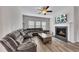 Cozy living room featuring a fireplace, ceiling fan, and a large sectional sofa at 525 Appalachian Pl, Canton, GA 30114