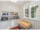 Charming butler's pantry featuring custom cabinets, open shelving, a microwave, and a rolling island at 890 W Wesley Nw Rd, Atlanta, GA 30327