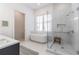 Bright bathroom featuring a glass enclosed shower, soaking tub, and neutral color palette at 1200 Ponce De Leon Ne Ave # A-19, Atlanta, GA 30306