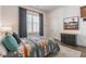 Cozy bedroom with soft rug, accent wall decor, and natural light from a large window at 1200 Ponce De Leon Ne Ave # A-19, Atlanta, GA 30306
