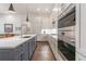 Modern kitchen featuring stainless steel appliances, white cabinets, gray island, and hardwood floors at 1200 Ponce De Leon Ne Ave # A-19, Atlanta, GA 30306