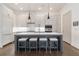 White kitchen with a gray island, seating for four, stainless steel appliances, and hardwood floors at 1200 Ponce De Leon Ne Ave # A-19, Atlanta, GA 30306