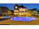 Night view of the beautiful backyard featuring a sparkling pool, hot tub, covered patio, and ambient lighting at 3185 Casteel Ne Rd, Marietta, GA 30062